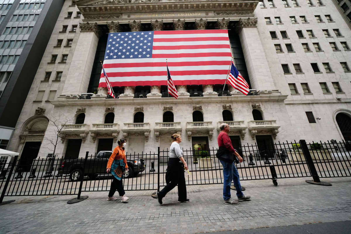 People walk on the sidewalk in front of the new york stock exchange