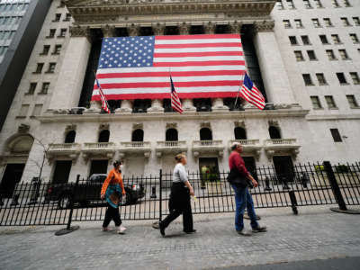 People walk on the sidewalk in front of the new york stock exchange
