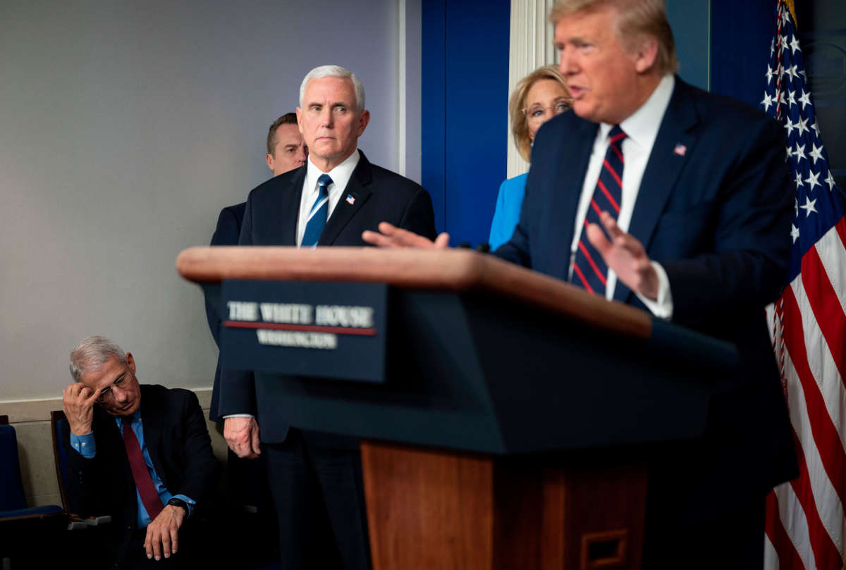 Director of the National Institute of Allergy and Infectious Diseases Dr. Anthony Fauci scratches his head and Vice President Pence looks on as President Trump speaks during the daily briefing on the novel coronavirus, COVID-19, in the Brady Briefing Room at the White House on March 27, 2020, in Washington, D.C.
