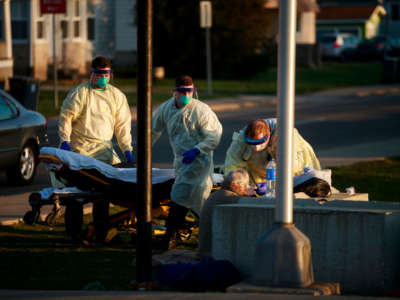 First responders from IU Health Bloomington hospital pick up a woman who described COVID-19 symptoms in Bloomington, Indiana.