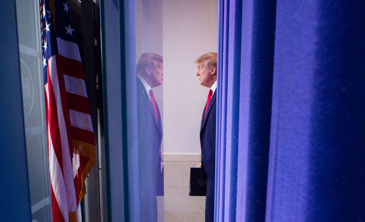 Donald Trump stands across from his own reflection