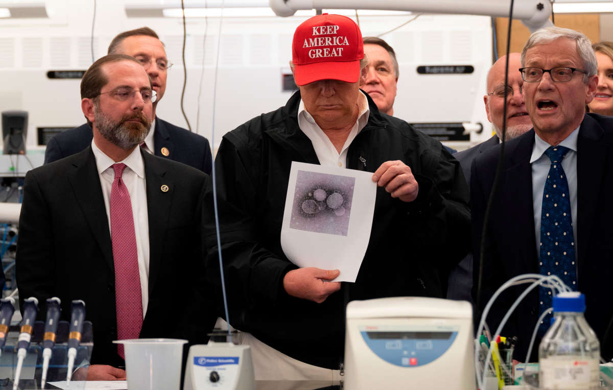 President Trump holds a picture of the coronavirus during a tour of the Centers for Disease Control and Prevention in Atlanta, Georgia, on March 6, 2020.