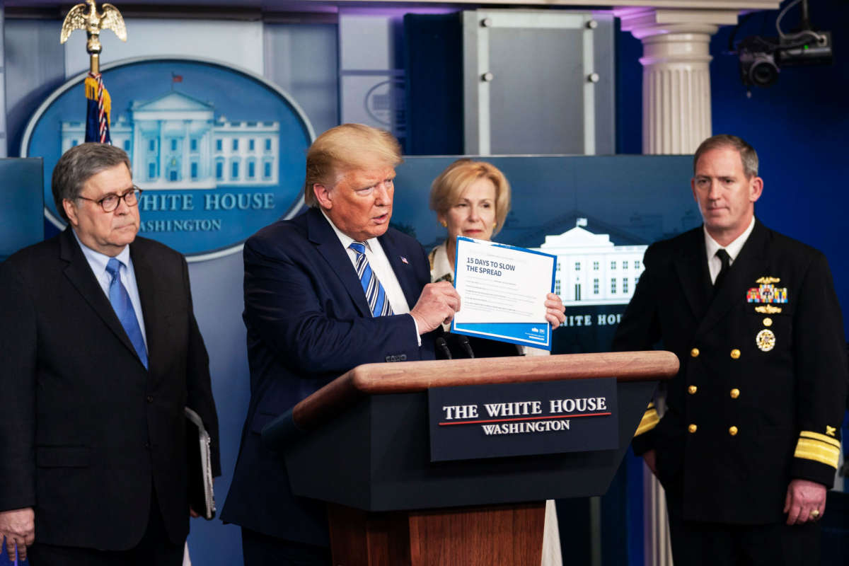 President Trump holds a copy of the president’s coronavirus guidelines brochure at a COVID-19 update briefing on March 23, 2020, in the James S. Brady Press Briefing Room of the White House.