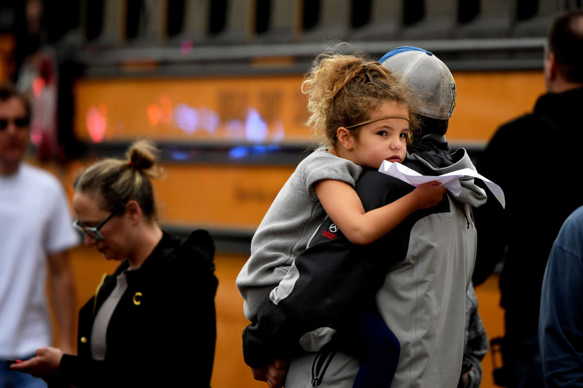 A child is held while waiting to get on their evacuation busses after a shooting at the STEM School Highlands Ranch on May 7, 2019, in Highlands Ranch, Colorado.