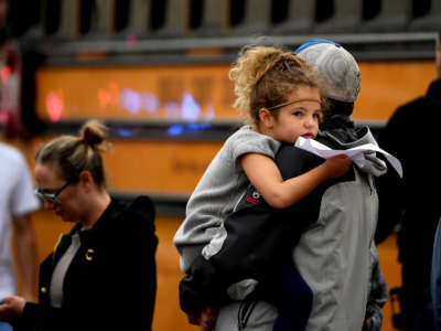 A child is held while waiting to get on their evacuation busses after a shooting at the STEM School Highlands Ranch on May 7, 2019, in Highlands Ranch, Colorado.