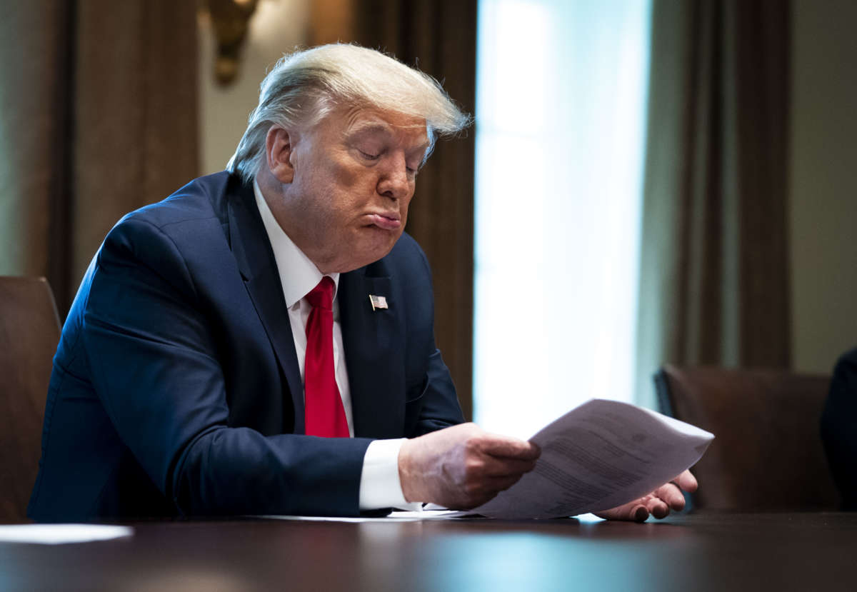Donald Trump sits at a desk