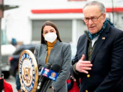 Senate Minority Leader Chuck Schumer speaks as Rep. Alexandria Ocasio-Cortez listens during a press conference in the neighborhood of Queens on April 14, 2020, in New York City.