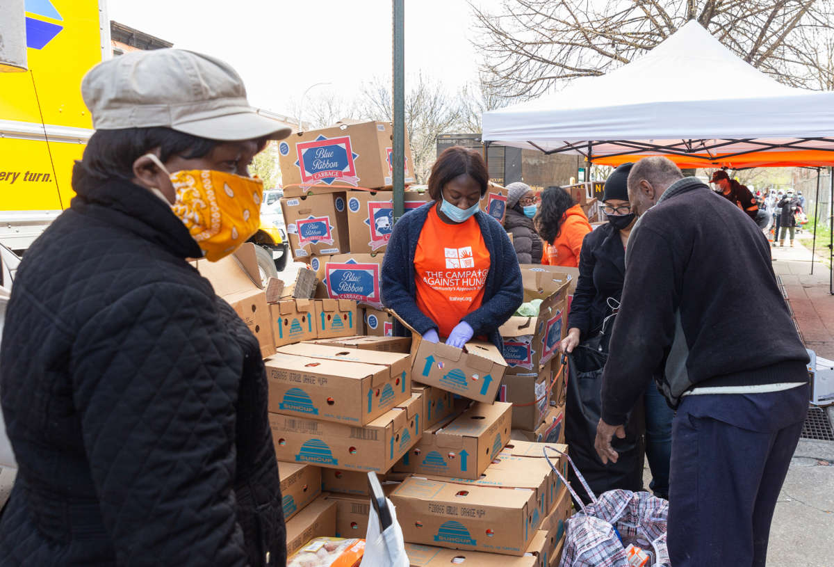 People pick up food for distribution by The Campaign Against Hunger amid the COVID-19 pandemic in the Brooklyn neighborhood of Bedford-Stuyvesant. This neighborhood is one of the poorest in the city and one of the hardest hit by the epidemic.