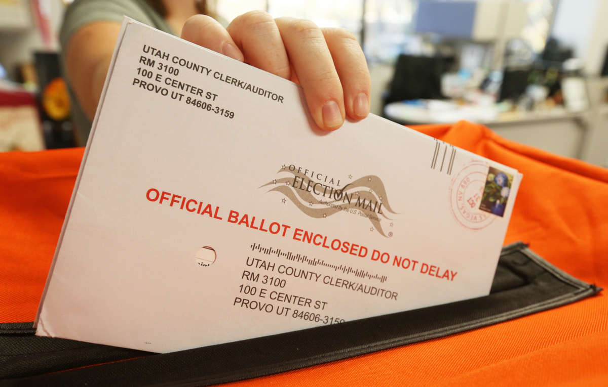 A employee at the Utah County Election office puts mail in ballots into a container to register the vote in the midterm elections on November 6, 2018, in Provo, Utah.