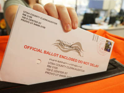 A employee at the Utah County Election office puts mail in ballots into a container to register the vote in the midterm elections on November 6, 2018, in Provo, Utah.