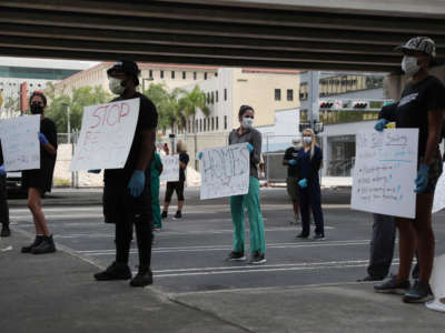 Volunteers, health care workers and doctors participate in a protest against what they say is the city's and county's poor response to helping the homeless during the coronavirus outbreak on April 17, 2020, in Miami, Florida.