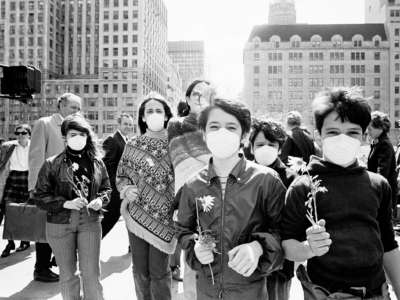 Vintage children wear face masks and hold flowers during a protest