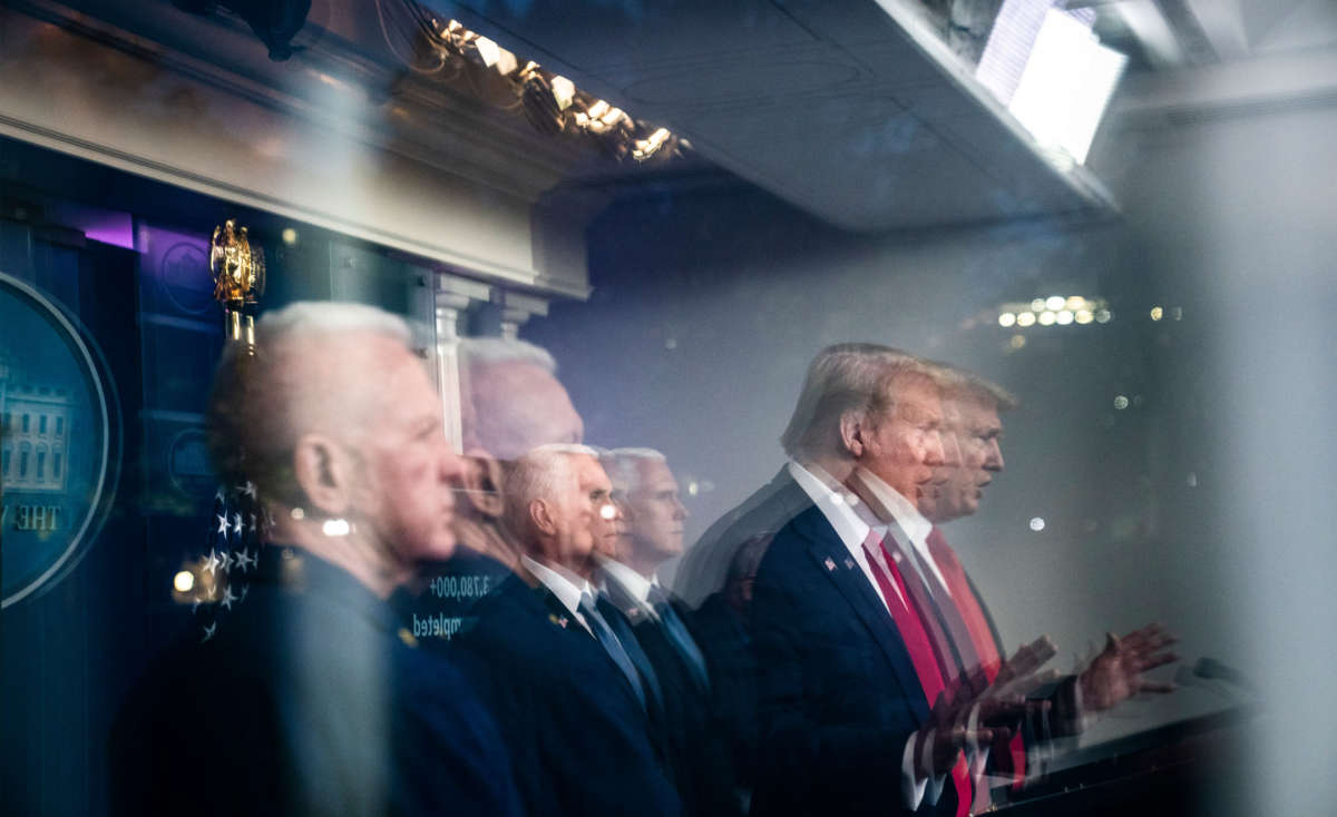 President Trump, seen reflected in a window, speaks with members of the coronavirus task force during a briefing in the James S. Brady Press Briefing Room at the White House on April 17, 2020, in Washington, D.C.