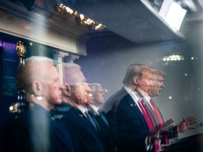 President Trump, seen reflected in a window, speaks with members of the coronavirus task force during a briefing in the James S. Brady Press Briefing Room at the White House on April 17, 2020, in Washington, D.C.