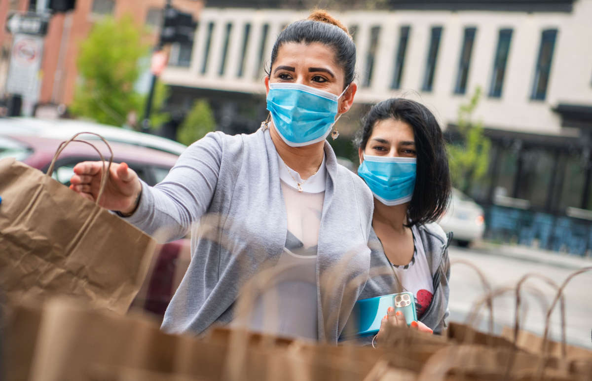 Restaurant industry workers affected by the coronavirus outbreak pick up donated food during a distribution organized by Saval Foodservice and Busboys and Poets at 14th and V Streets NW, on April 17, 2020.