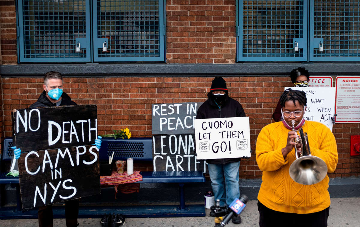 A woman plays a horn while taking part in a vigil outside Queensboro Correctional Facility on April 23, 2020, in New York City.