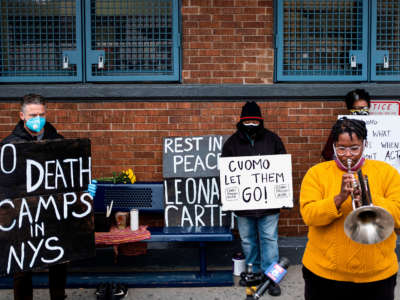 A woman plays a horn while taking part in a vigil outside Queensboro Correctional Facility on April 23, 2020, in New York City.