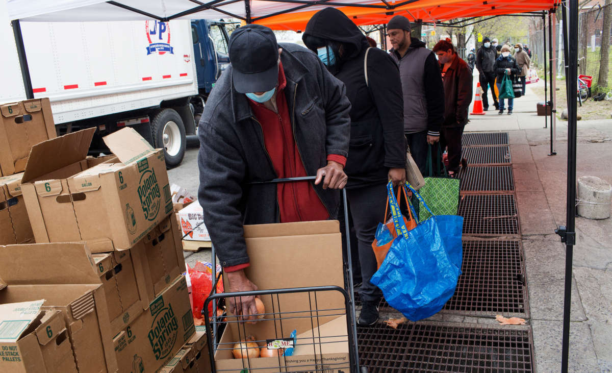 Local residents line up outside the food pantry Bed Stuy Campaign Against Hunger to receive free food during the COVID-19 pandemic on April 23, 2020, in the Bedford-Stuyvesant neighborhood of Brooklyn, New York.