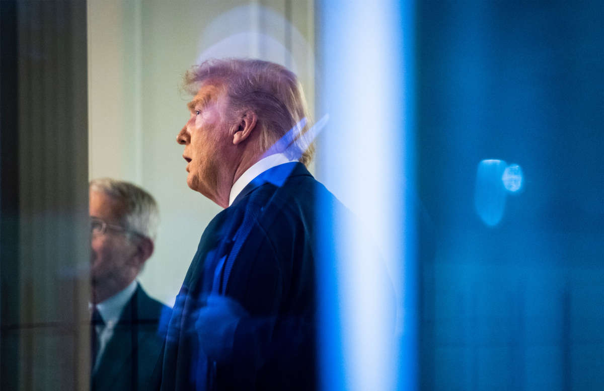 President Trump, seen through a window, watches a television in the press office as newscasters talk about him moments after he was speaking with members of the coronavirus task force during a briefing in the James S. Brady Press Briefing Room at the White House on April 22, 2020, in Washington, D.C.