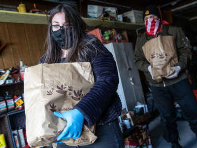Volunteers Marisa Decolator and Joe Gale deliver groceries to immigrants on lockdown due to coronavirus measures on April 16, 2020, in North Bellmore, New York. With little health insurance and no unemployment benefits, immigrant communities have been especially hard hit by COVID-19 and the economic effects of the prolonged crisis.