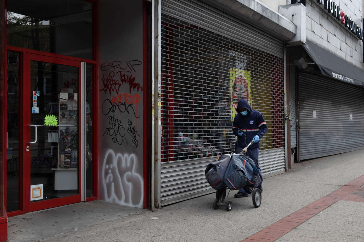 A postal worker delivers mail amid the coronavirus outbreak in New York City on April 9, 2020.