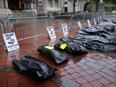 Mock body bags are lined up in front of the Trump International Hotel, set down by people demonstrating against President Donald Trump's response to the novel coronavirus pandemic now sweeping the United States April 23, 2020, in Washington, D.C.