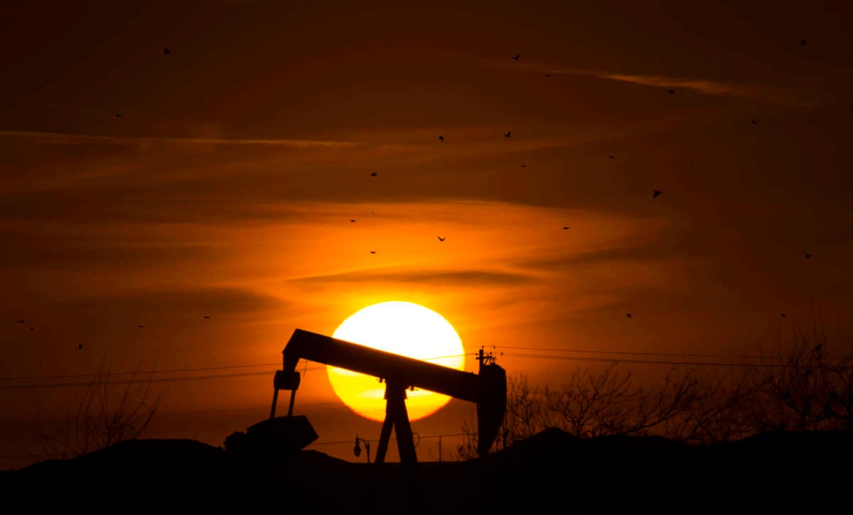 The sun sets behind an old oil well February 20, 2016, in Edmond, Oklahoma.