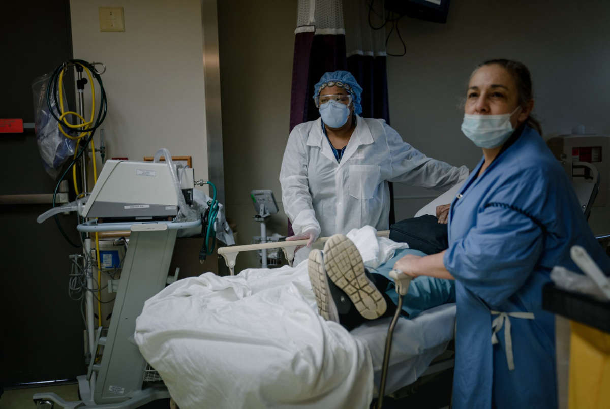 Medical staff in protective gear attend to a patient