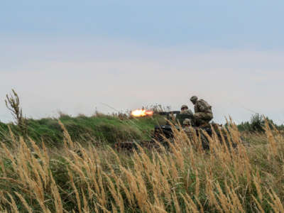 soldiers fire a gun