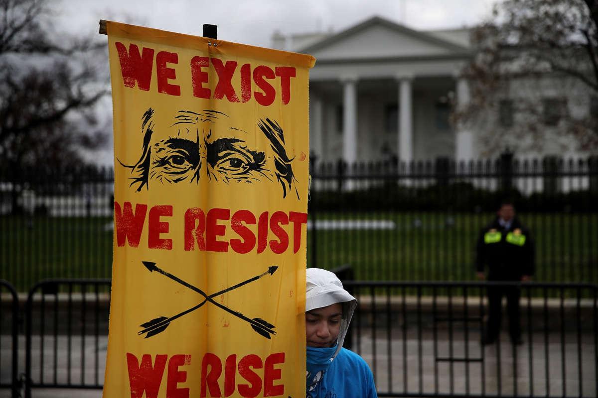 A protester holds a sign in front of the White House during a demonstration against the Dakota Access Pipeline on March 10, 2017, in Washington, D.C.