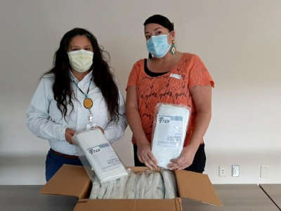 The Seattle Indian Health Board's Esther Lucero, left, and Abigail Echo-Hawk, right, with a box of body bags.