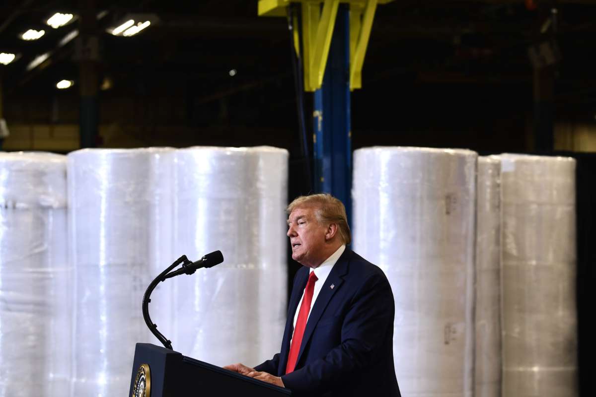 Donald Trump stands by manufacturing supplies while giving a speech