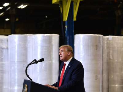 Donald Trump stands by manufacturing supplies while giving a speech