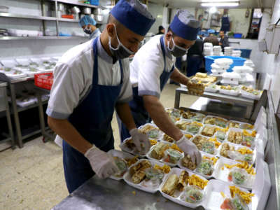 Palestinian chefs prepare meals for the needy in a commercial kitchen