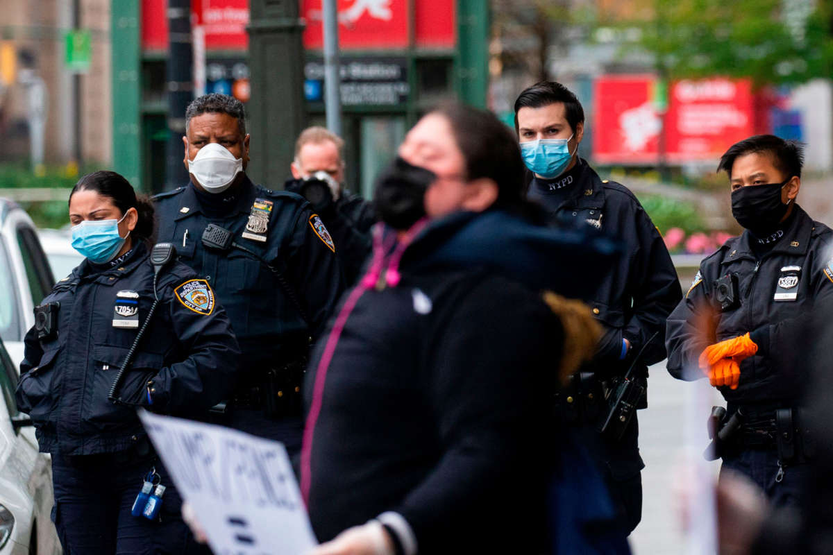 NYPD officers use face masks as they watch protestors demonstrating against President Trump in front of the Trump International Hotel on April 18, 2020, in New York City.