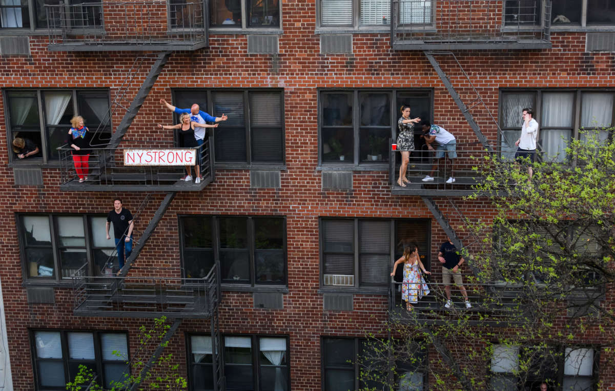 People applaud from their fire escapes to show their gratitude to medical staff and essential workers on the front lines of the coronavirus pandemic during the coronavirus pandemic in the Upper East Side on May 2, 2020, in New York City.