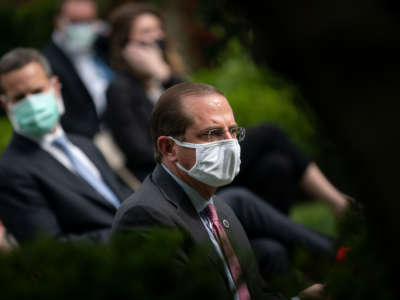 Secretary of Health and Human Services Alex Azar and others wear face masks while attending a press briefing about coronavirus testing in the Rose Garden of the White House on May 11, 2020, in Washington, D.C.