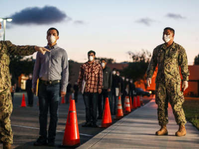 U.S. Marine recruits stand in formation as they wait in line for health screenings at the Marine Corps Recruit Depot on April 13, 2020, in San Diego, California.