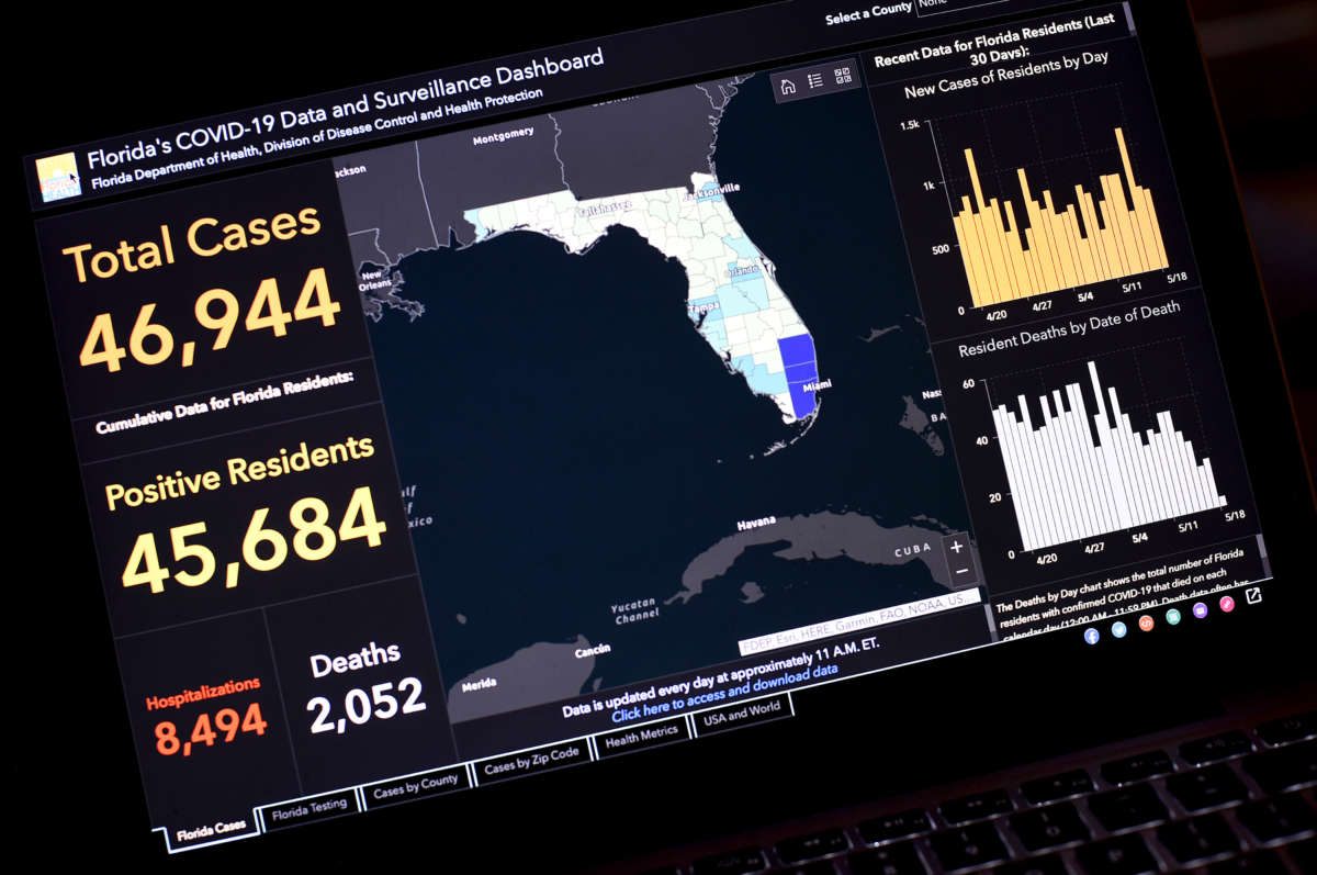 A laptop displays a COVID tracking app for Florida