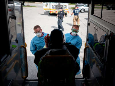 Paramedics and firefighters with Anne Arundel County Fire Department load a presumptive COVID-19 patient onto the ambulance on April 21, 2020, in Glen Burnie, Maryland.