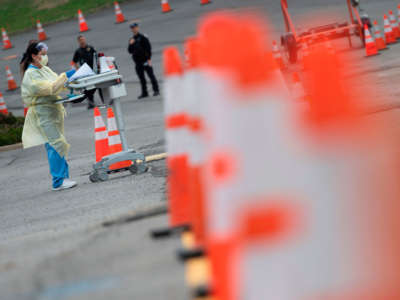 Health care workers from the Virginia Hospital Center prepare before people arrive at a drive through testing site for coronavirus in Arlington, Virginia, on March 20, 2020.