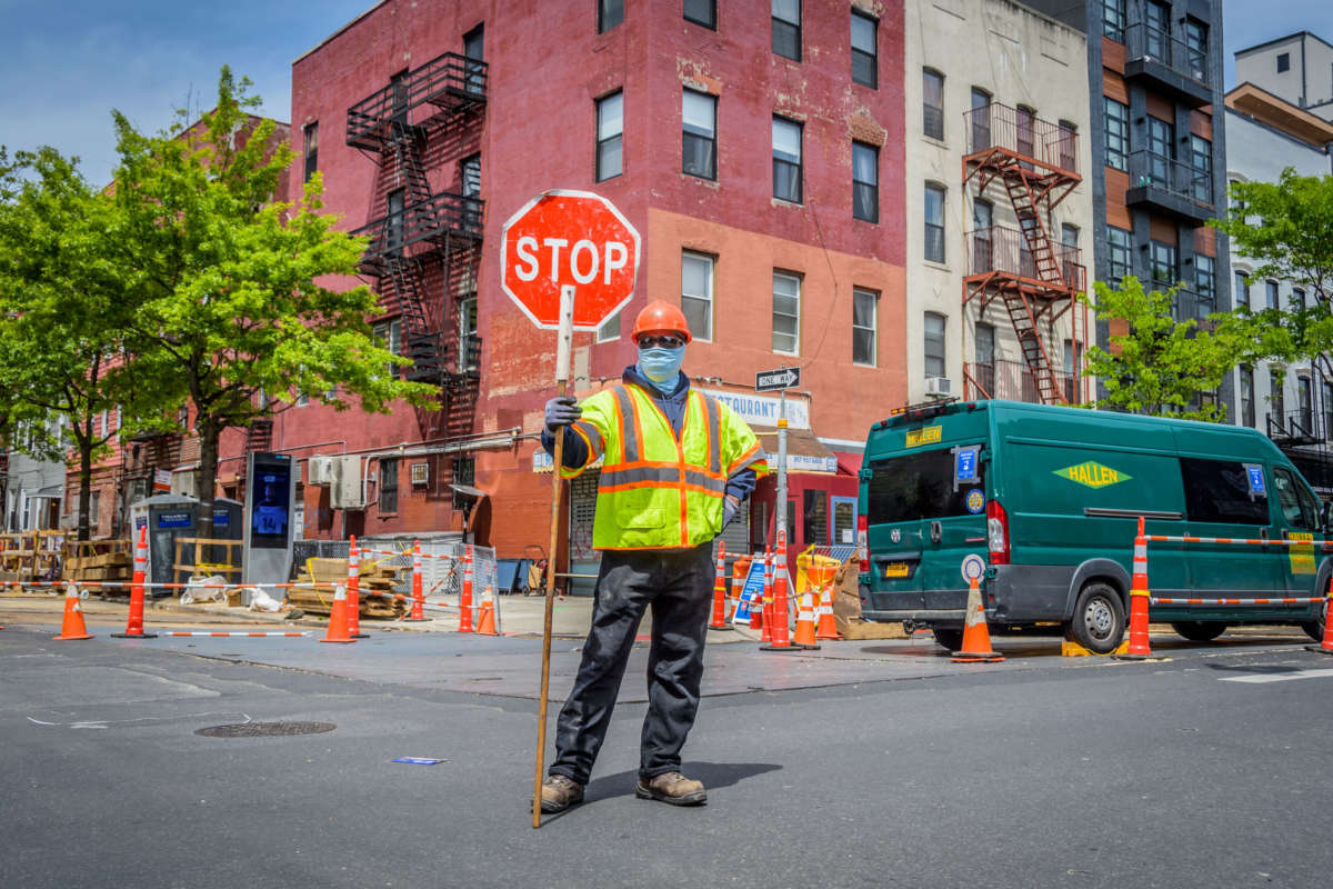 Construction workers wear protective face masks in the streets of Bushwick, New York, on May 19, 2020.