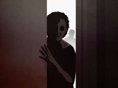 Woman leans through dark doorway with shadow behind her