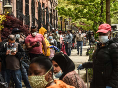 People wait on a long line to receive a food bank donation at the Barclays Center on May 15, 2020, in the Brooklyn borough in New York City.