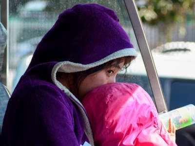 A child sits on a bus with migrants deported from the United States outside the air force base in Guatemala City on December 27, 2019.