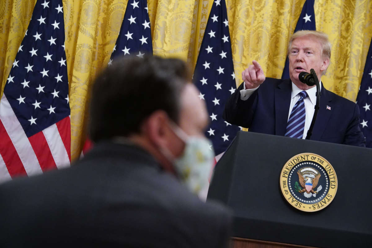 A member of the audience wearing a mask listens to President Trump speak in the East Room of the White House in Washington, D.C., on April 30, 2020.