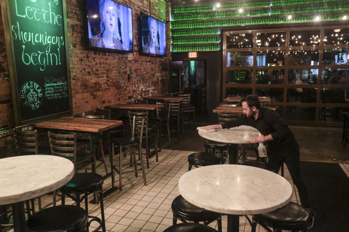 Waiters and bartenders clean up bars and restaurants along North High Street in the Short North District on March 15, 2020, in Columbus, Ohio.