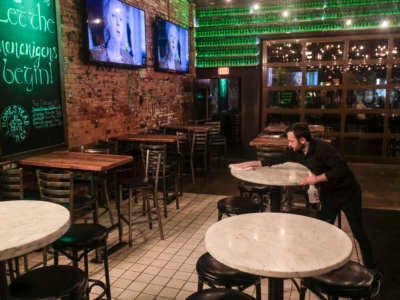 Waiters and bartenders clean up bars and restaurants along North High Street in the Short North District on March 15, 2020, in Columbus, Ohio.