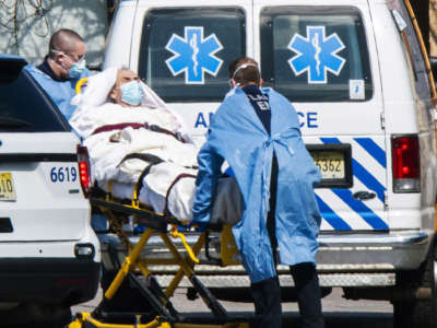 Medical workers load a patient from Andover Subacute and Rehabilitation Center into an ambulance while wearing masks and personal protective equipment on April 16, 2020, in Andover, New Jersey.