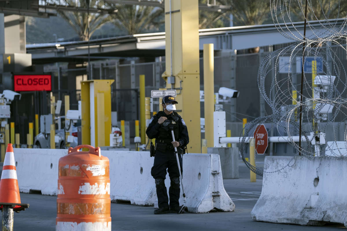 A Customs and Border Protection agent is seen wearing a face mask as a preventive measure to avoid the spread of COVID-19 coronavirus, at San Ysidro crossing from Tijuana, Baja California state, Mexico, on April 23, 2020, on the U.S.-Mexico border.